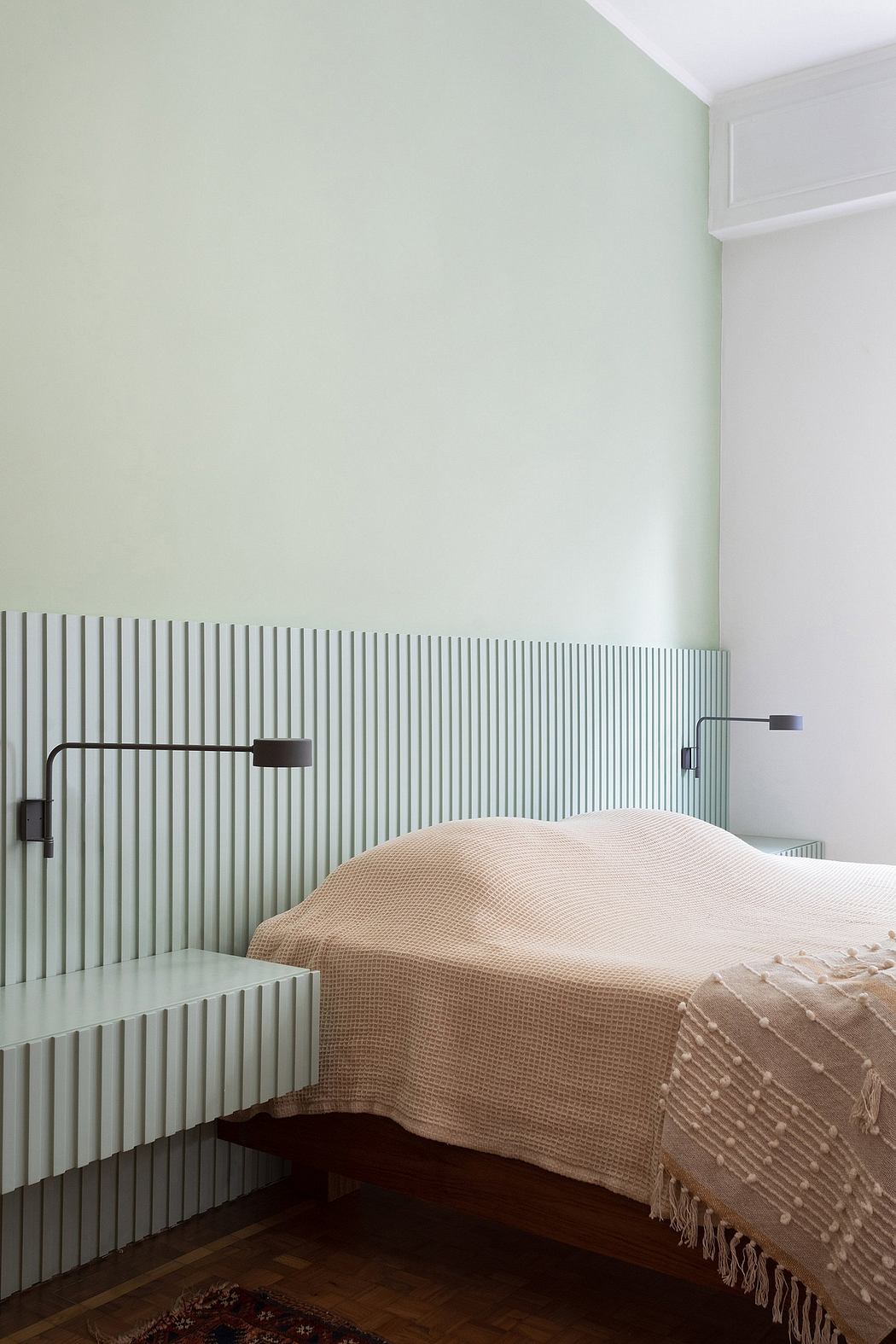Minimalist bedroom with slatted headboard and soft neutral-toned bedding.