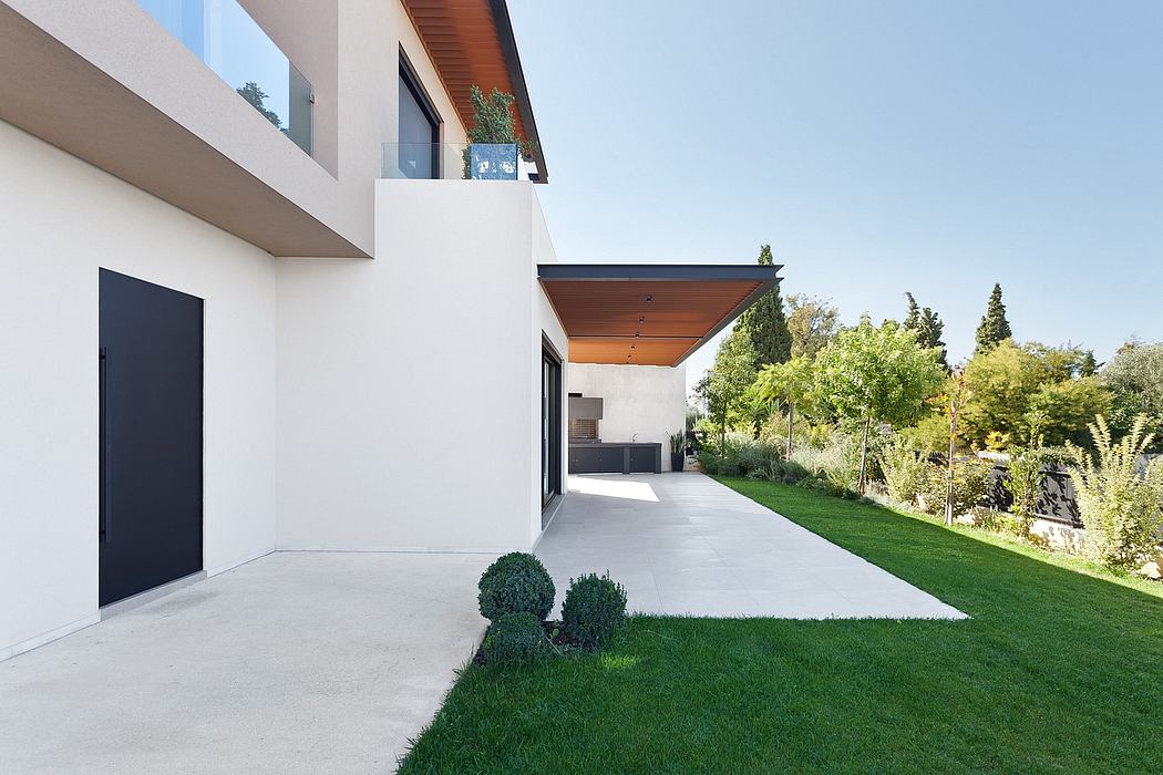 Modern architecture with wooden roof, concrete walls, and lush landscaping.
