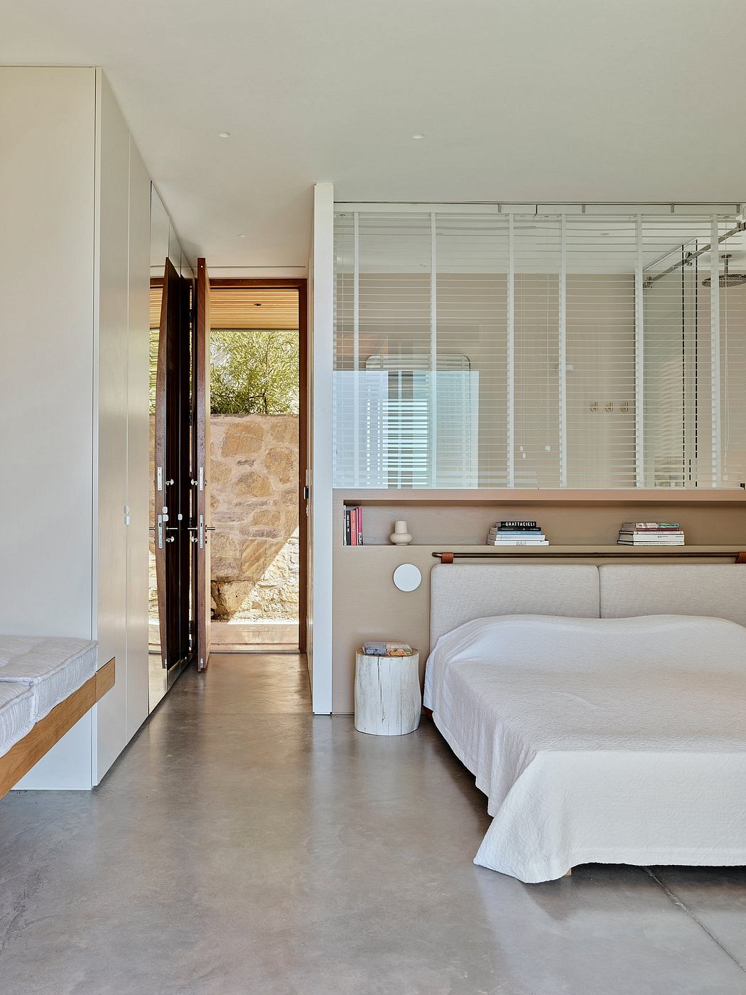 Minimalist bedroom featuring concrete floors, wooden shelving, and a glass-paneled wall.