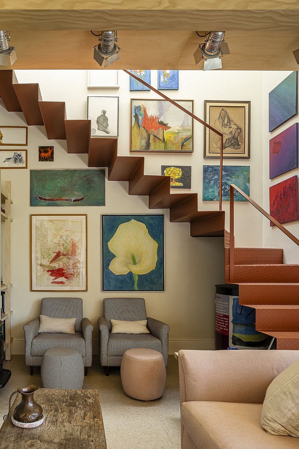Eclectic art-filled interior with rustic wood stairs, plush seating, and gallery-style wall display.