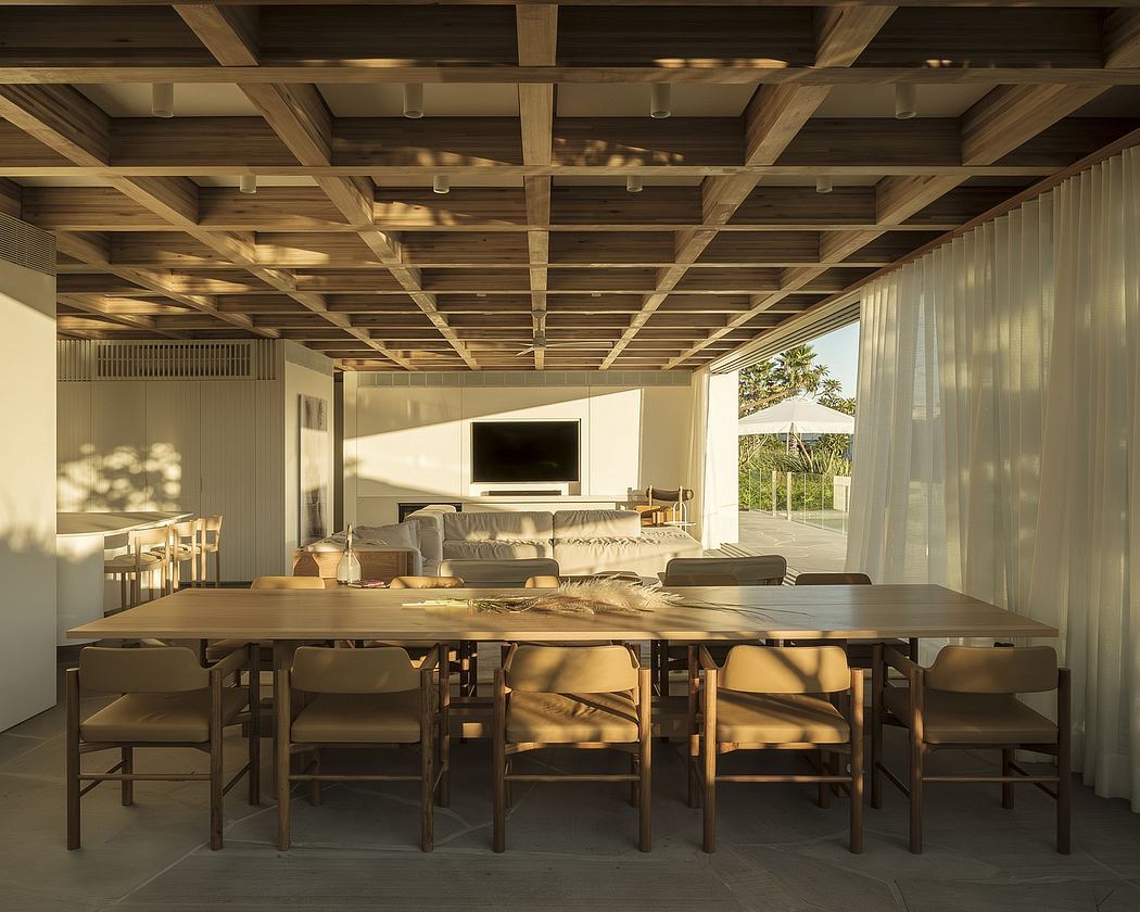 Warm-toned wooden ceiling beams, expansive dining area, and sliding glass doors reveal a scenic view.