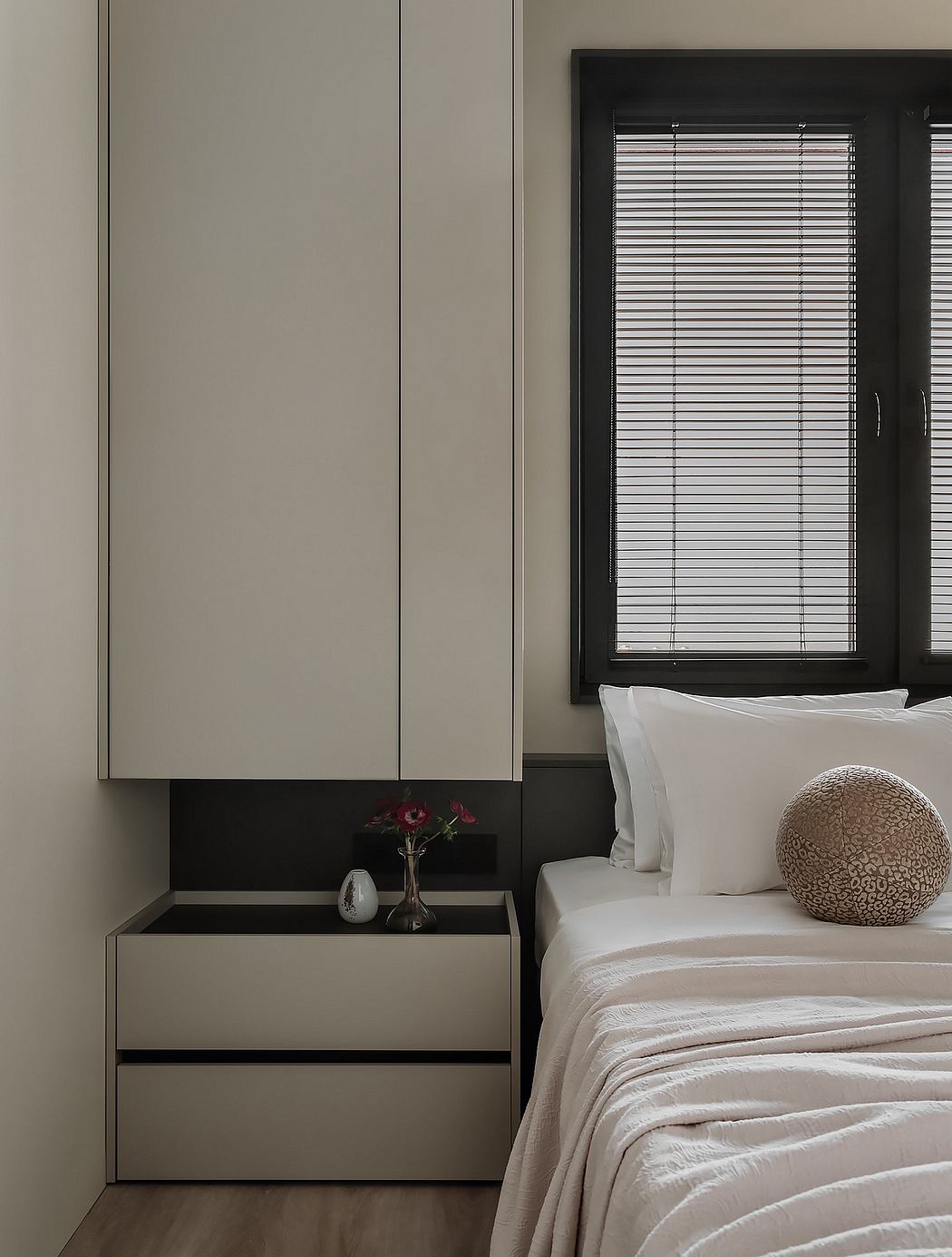 Minimalist bedroom with built-in wardrobe, bedside table, and textured decor.