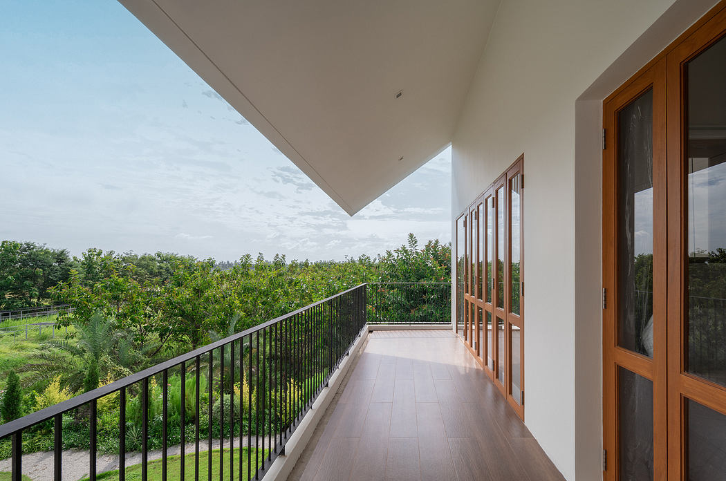 Spacious balcony with wooden framing, glass panels, and panoramic views of lush greenery.