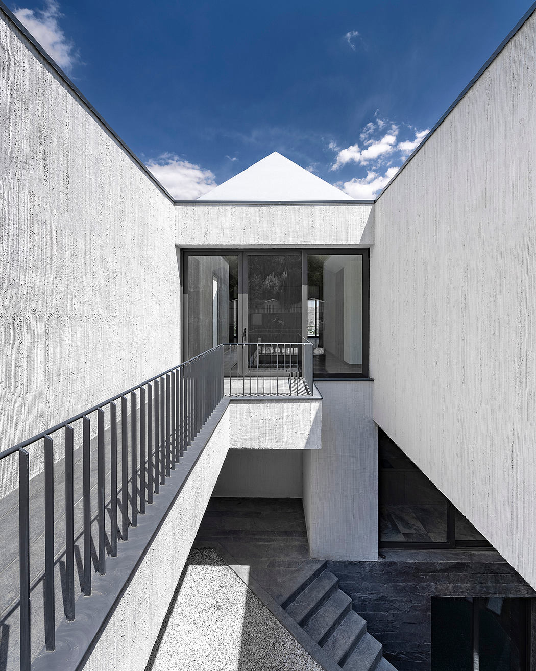 Stark, angular exterior with an inviting open entryway and modern architectural details.