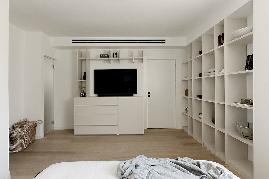 Minimalist bedroom design with built-in storage, TV console, and clean, neutral tones.