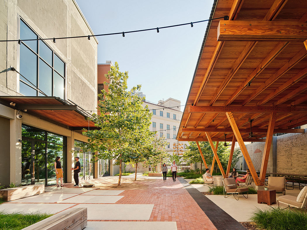 Outdoor courtyard with wooden canopy, brick paving, and glass-walled businesses.