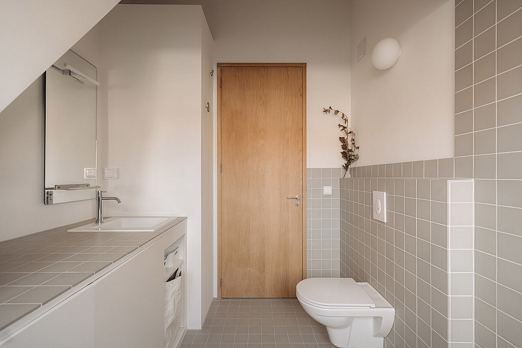 Minimalist bathroom with wooden door, tiled walls, and vanity unit with countertop.