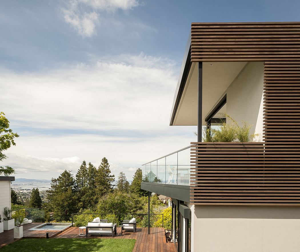 Modern home exterior with wooden slat siding, expansive deck, and scenic mountain view.