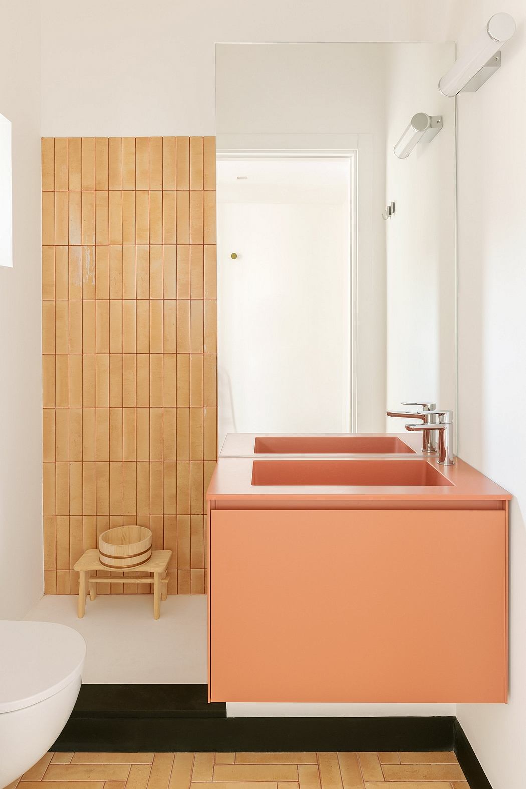 Sleek, modern bathroom design featuring wooden panels, orange vanity, and minimalist fixtures.