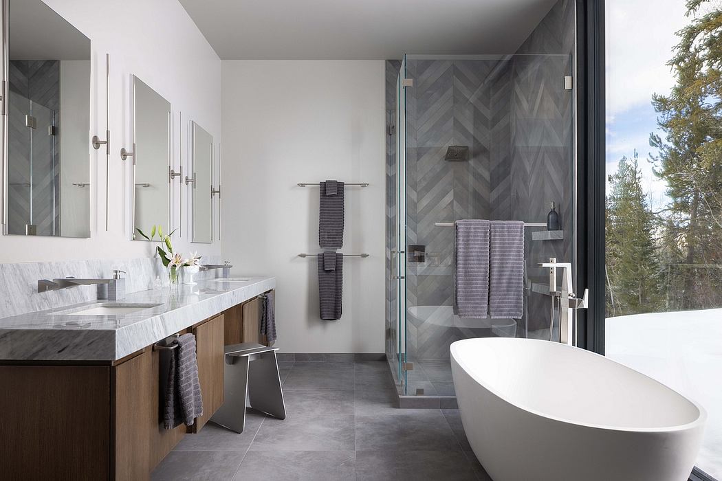 A modern, minimalist bathroom with a freestanding tub, vanity, and glass shower enclosure.