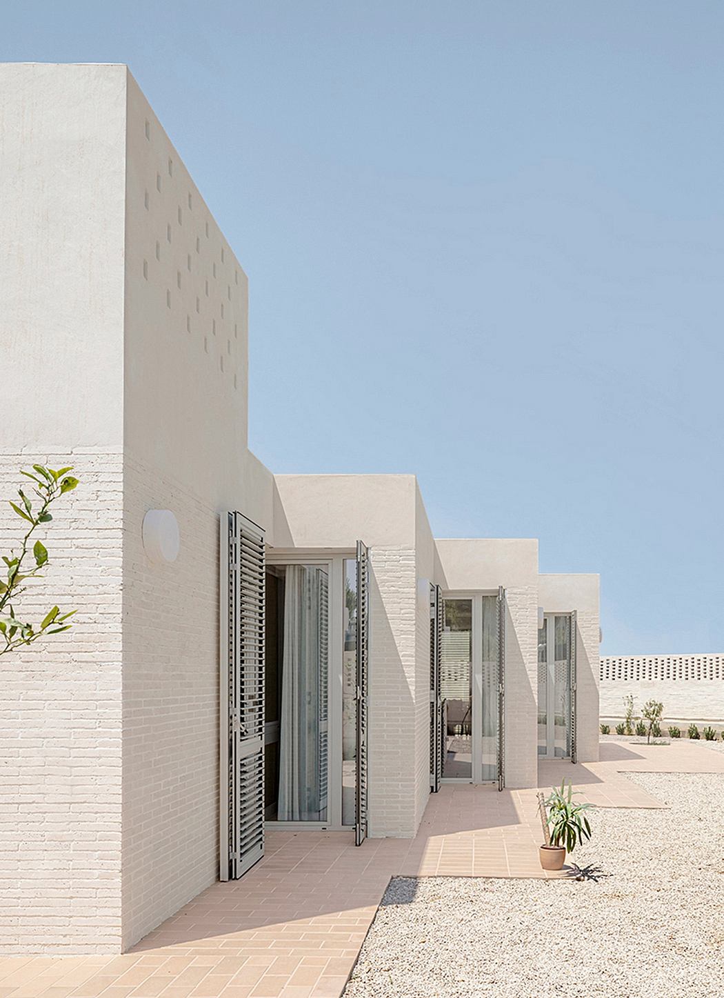 Clean, geometric lines and textured facades create a minimalist, modern architectural design.