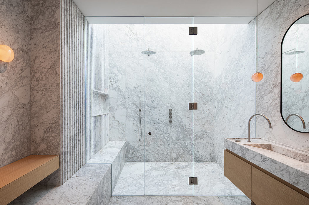 Luxurious bathroom with floor-to-ceiling marble walls, sleek glass shower, and modern fixtures.