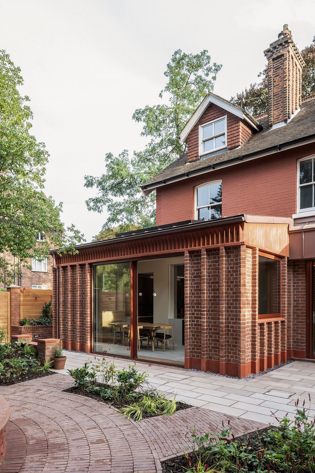A brick-and-wood structure with a large glass wall, recessed entryway, and decorative trim.