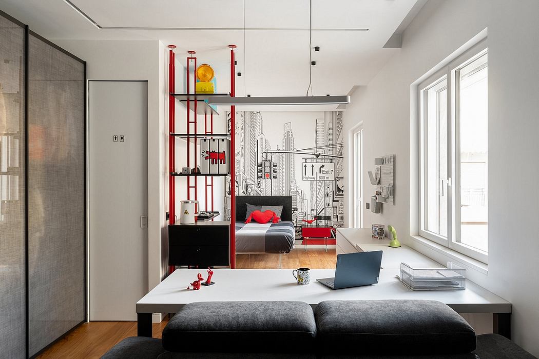 A modern, open-plan studio apartment with minimalist furnishings and a bold, graphic wall mural.