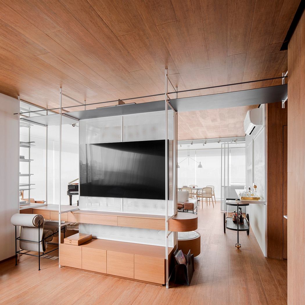 Modern living space with wood paneling, glass dividers, and a large TV display.