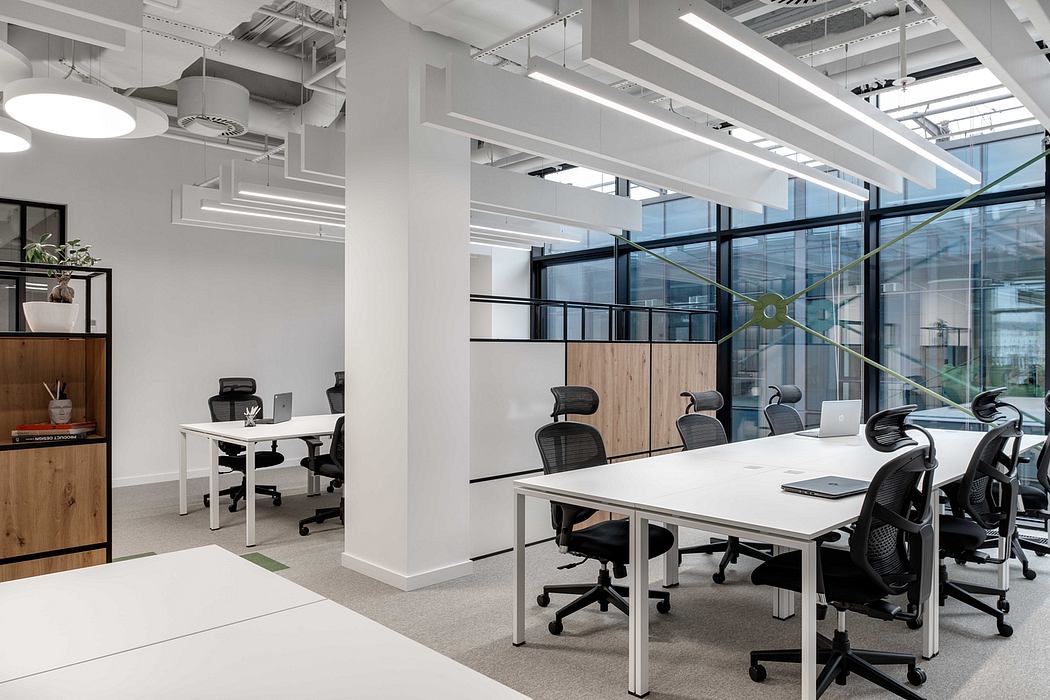A bright, modern office space with wood accents, white desks, and sleek lighting fixtures.