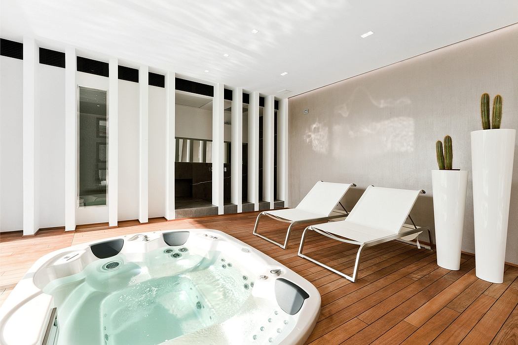Modern and minimalist spa-inspired interior with jacuzzi, chaise lounges, and potted cacti.