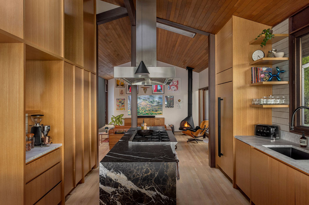 Warm wooden interior with black marble countertops, a fireplace, and hanging artwork.
