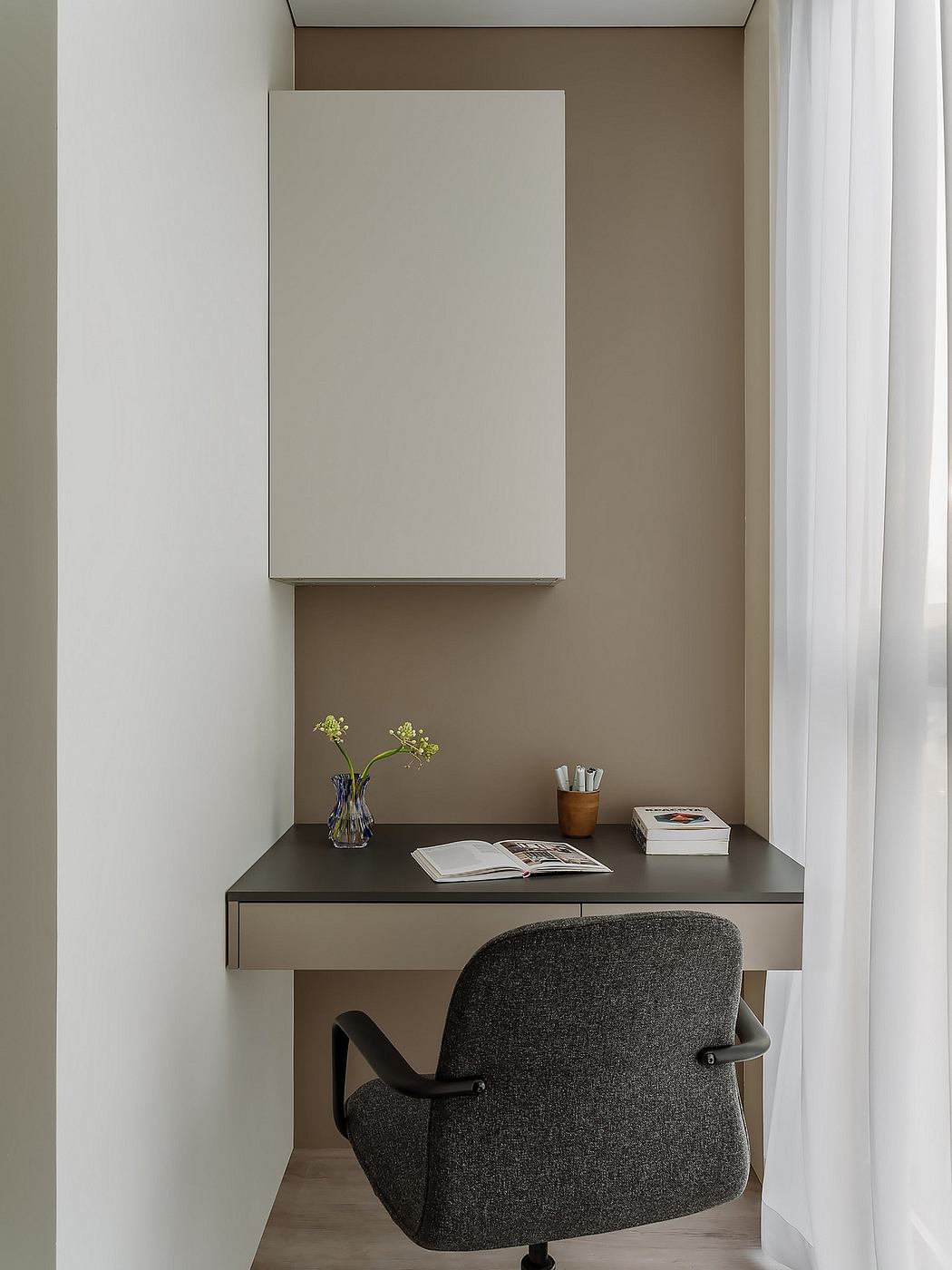 A minimalist home office with a sleek floating desk, chair, and decorative elements.