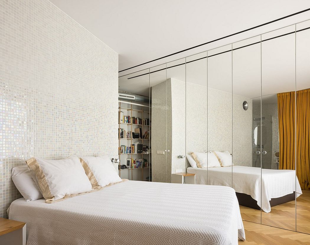Minimalist bedroom design with white mosaic tile walls, built-in bookshelves, and sliding mirrored closets.