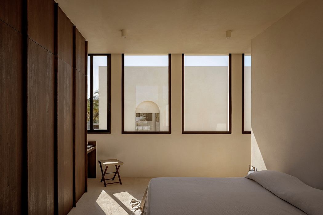 Minimalist bedroom design with floor-to-ceiling windows, wood paneling, and recessed lighting.