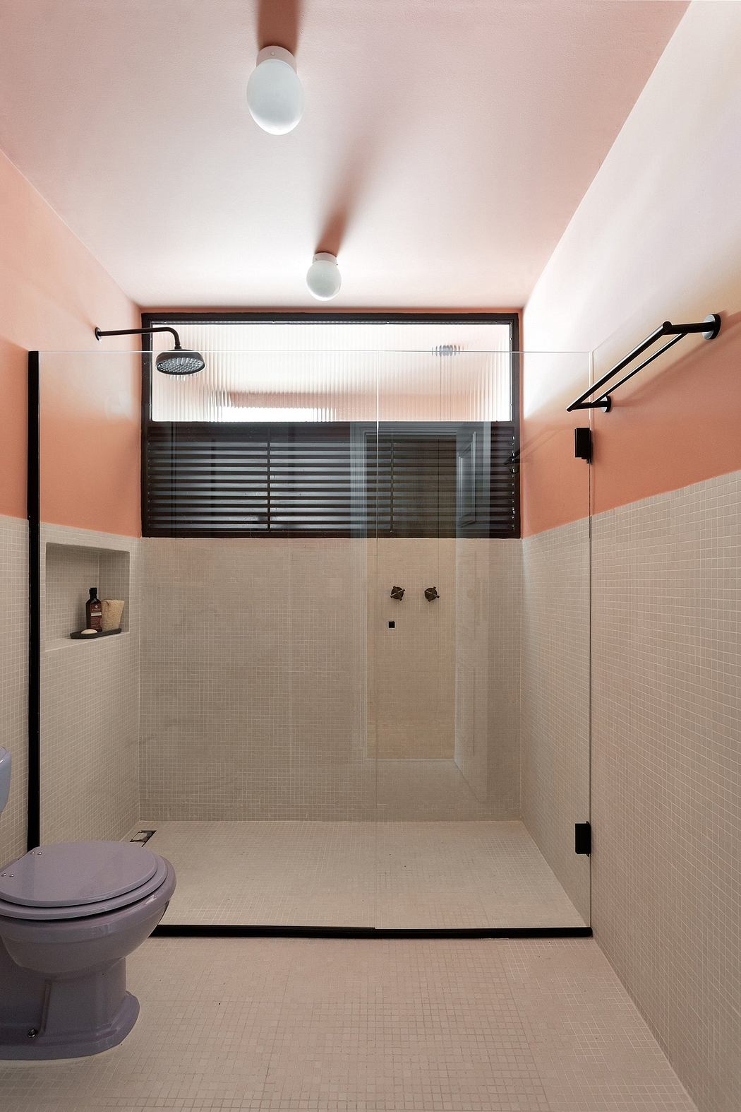 Modern bathroom with tiled floors, glass shower enclosure, and minimalist black fixtures.