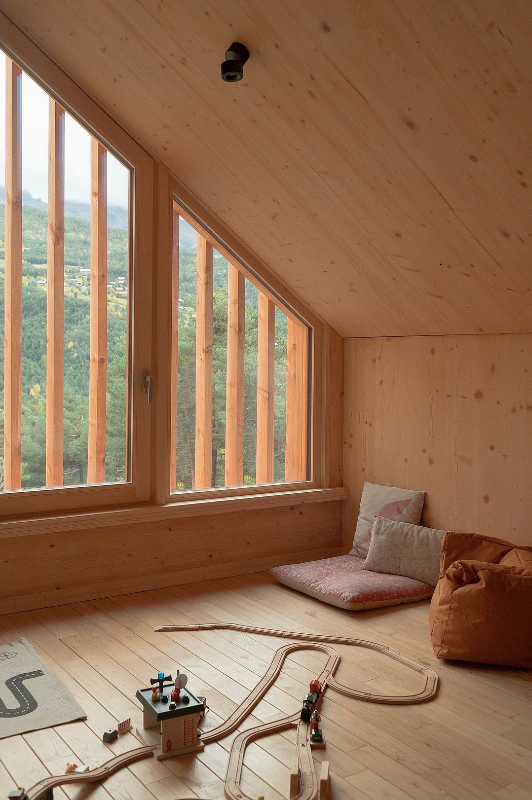 Cozy wooden interior with large windows showcasing a scenic mountain view. Warm, inviting atmosphere.