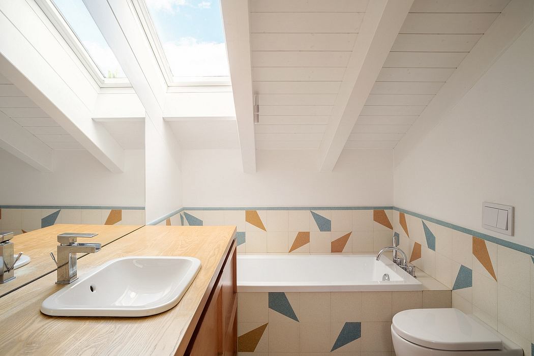 Sleek, modern bathroom with geometric tile pattern, skylights, and wooden vanity.