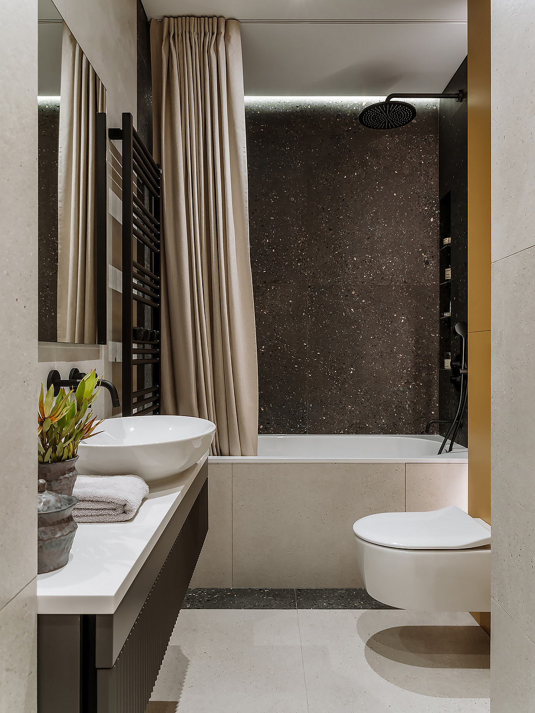 A modern bathroom with sleek black and white tiles, a white sink, and a shower curtain.