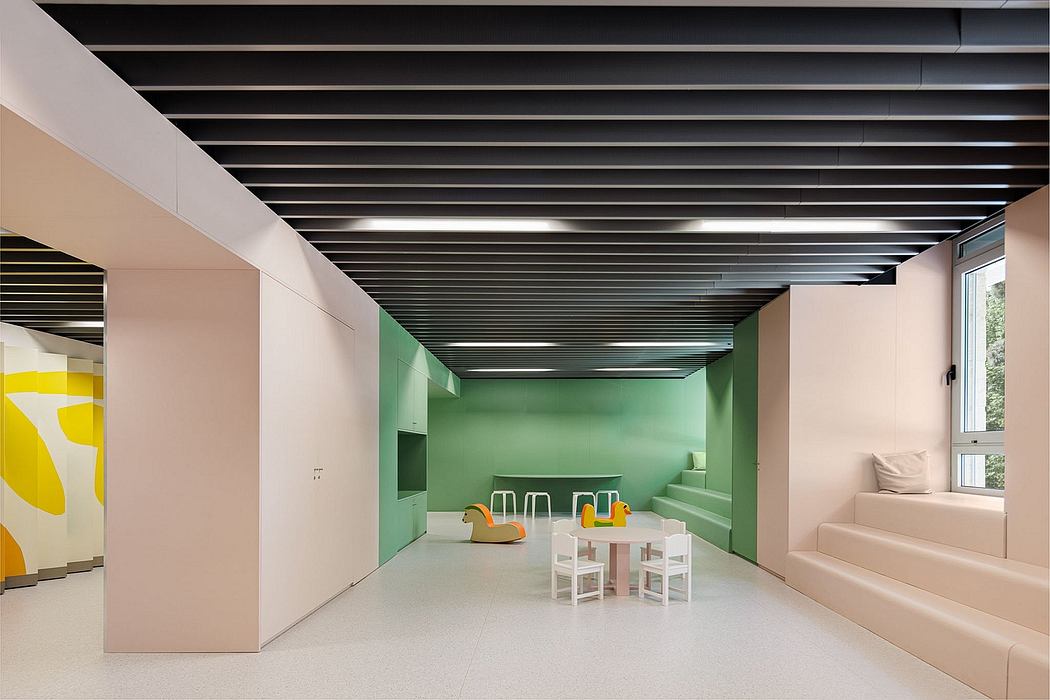 An interior space with a modern, minimalist design featuring colorful accents, clean lines, and a suspended ceiling.