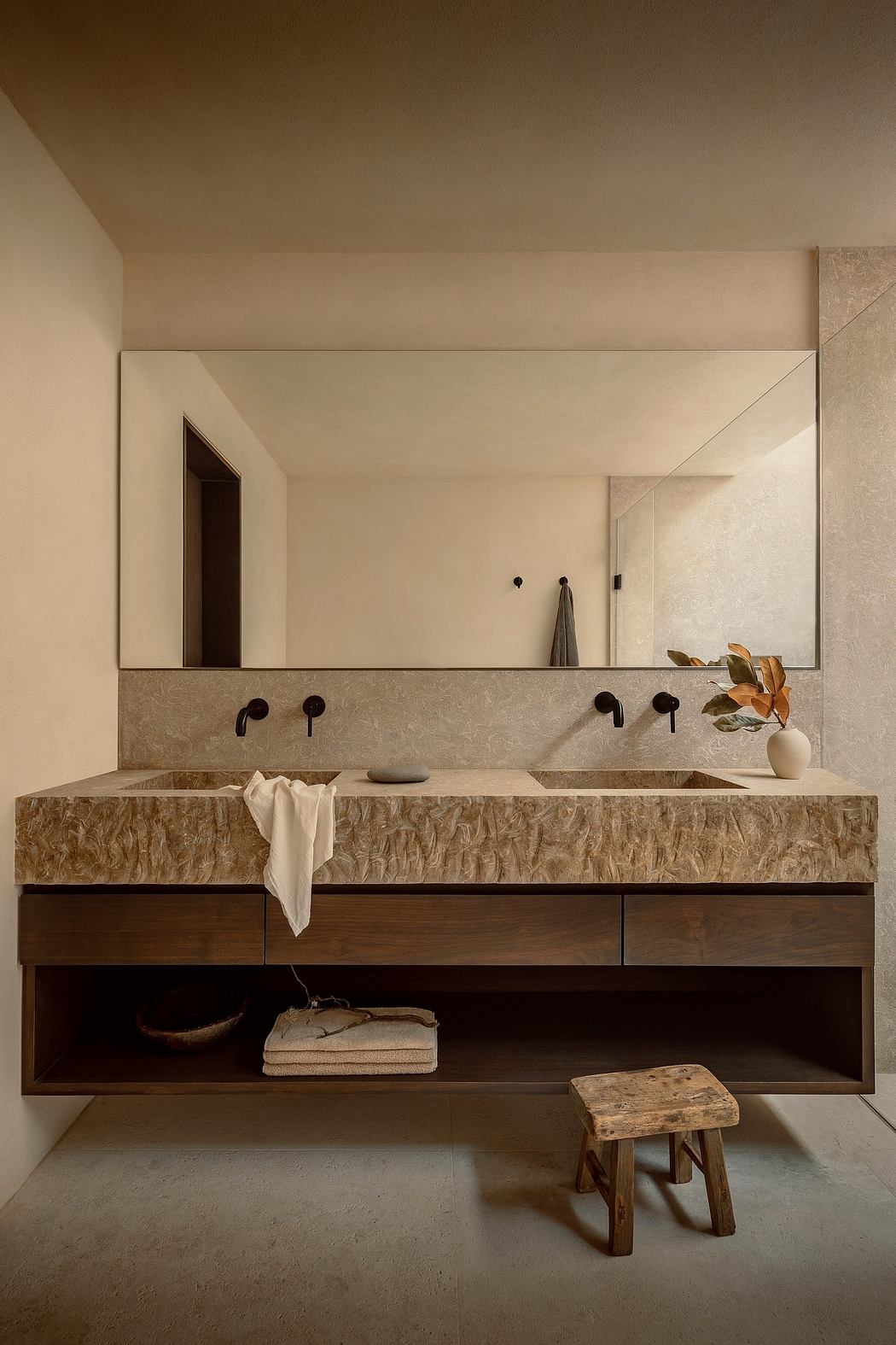 Minimalist bathroom with sleek stone vanity, recessed lighting, and rustic accents.