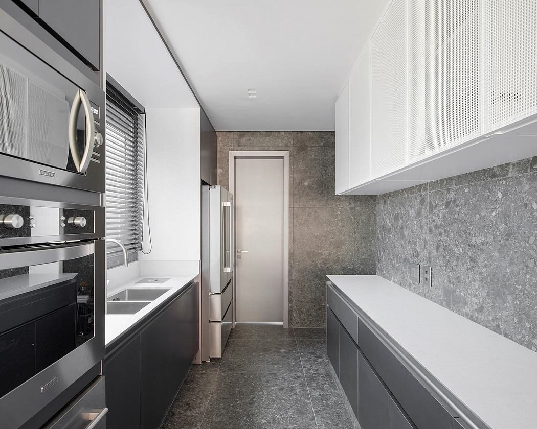 Sleek, modern kitchen with clean lines, gray tile backsplash, and built-in appliances.