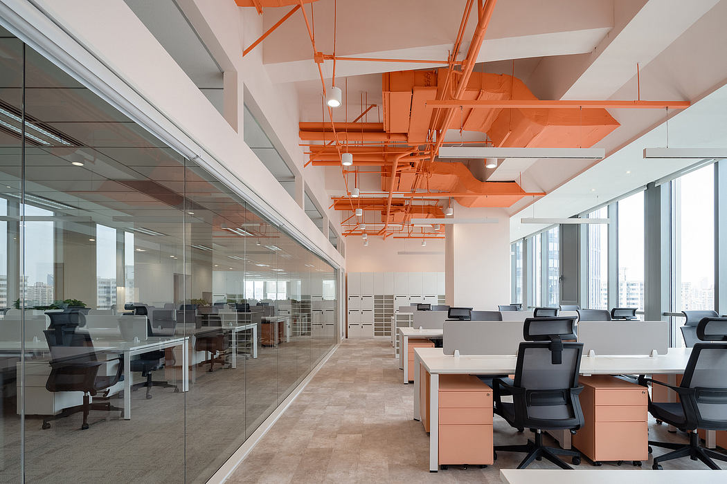 Airy, modern office space with minimalist furniture and vibrant orange ceiling accents.
