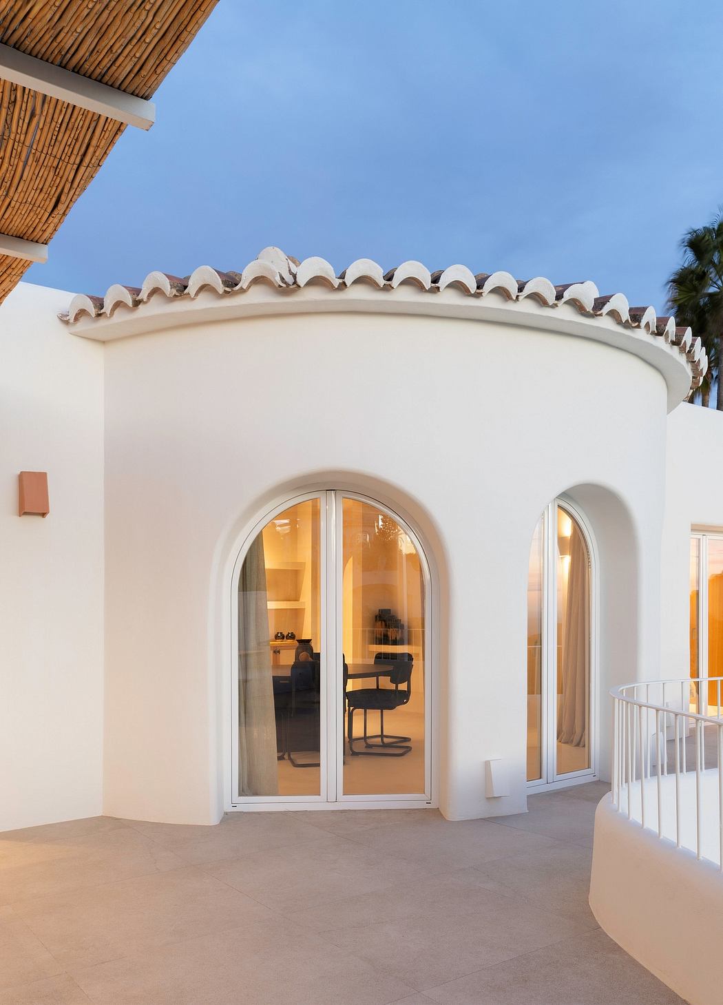 The arched doorways and tiled roof details create a Mediterranean-inspired architectural style.