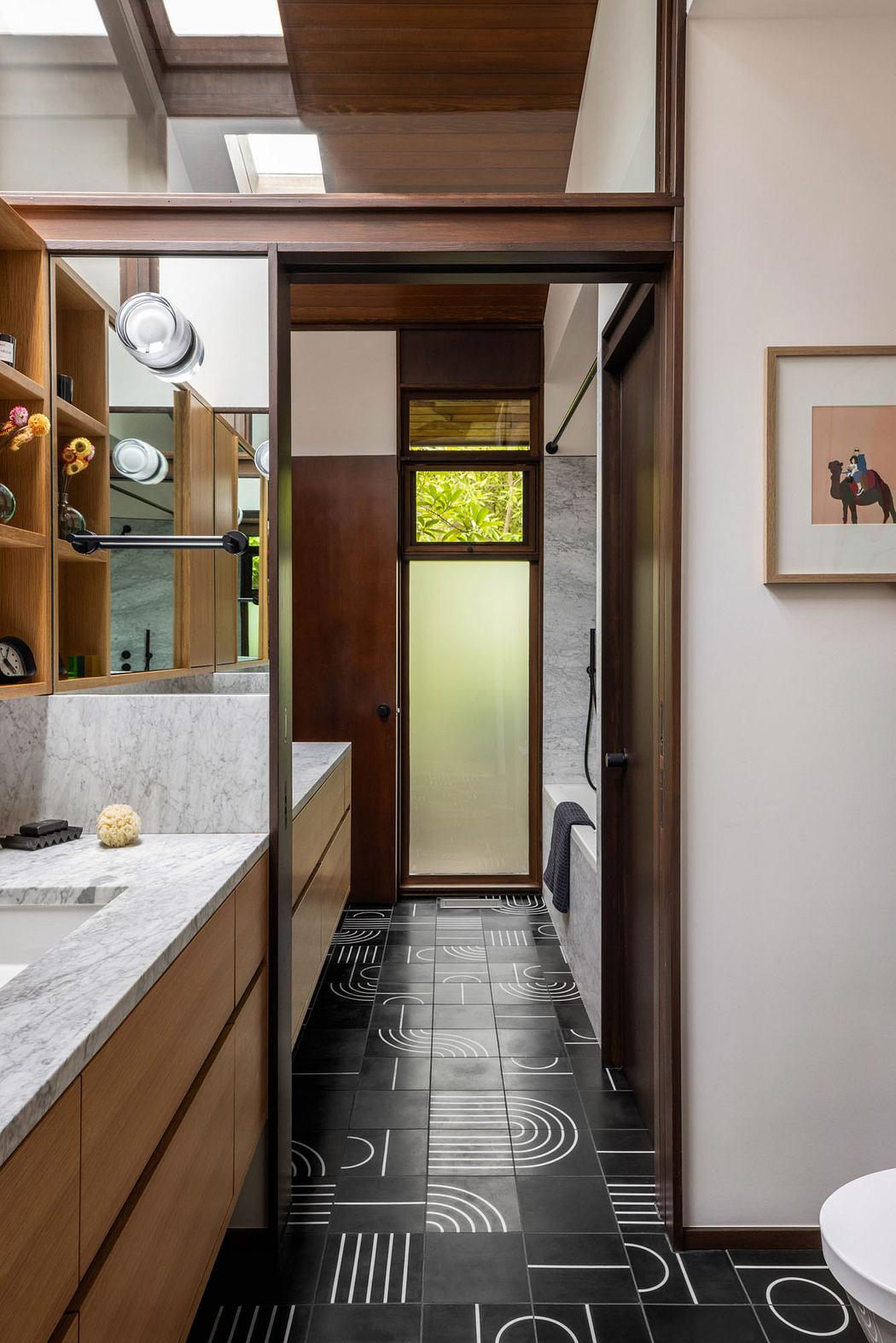 A modern bathroom with a sleek wooden cabinetry, marble countertop, and patterned tile flooring.