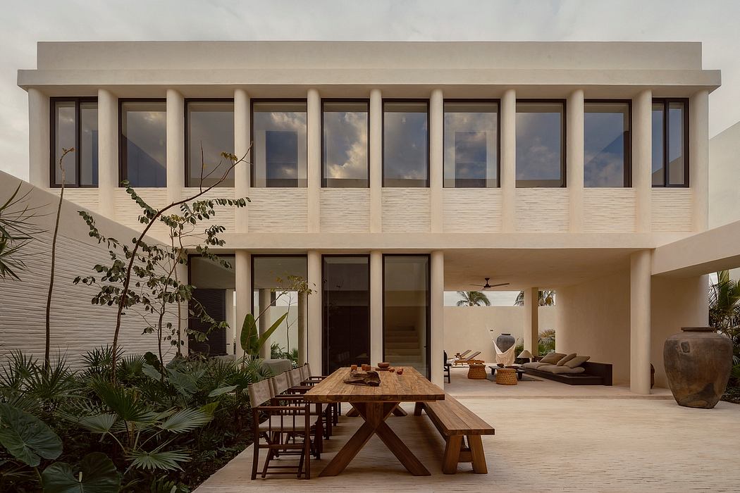 A modern, minimalist villa with a large open-plan living area and dining terrace.