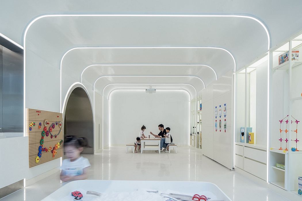 Bright, minimalist interior with curved archways and recessed lighting; children's play area.