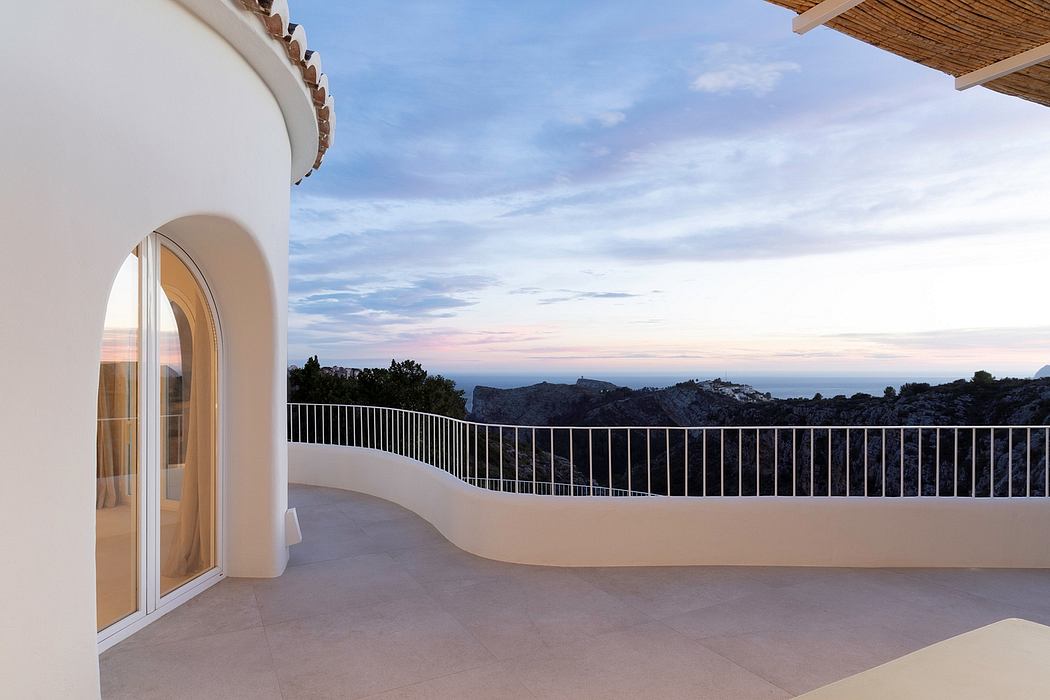 Balcony with arched windows and metal railing overlooking a breathtaking view.