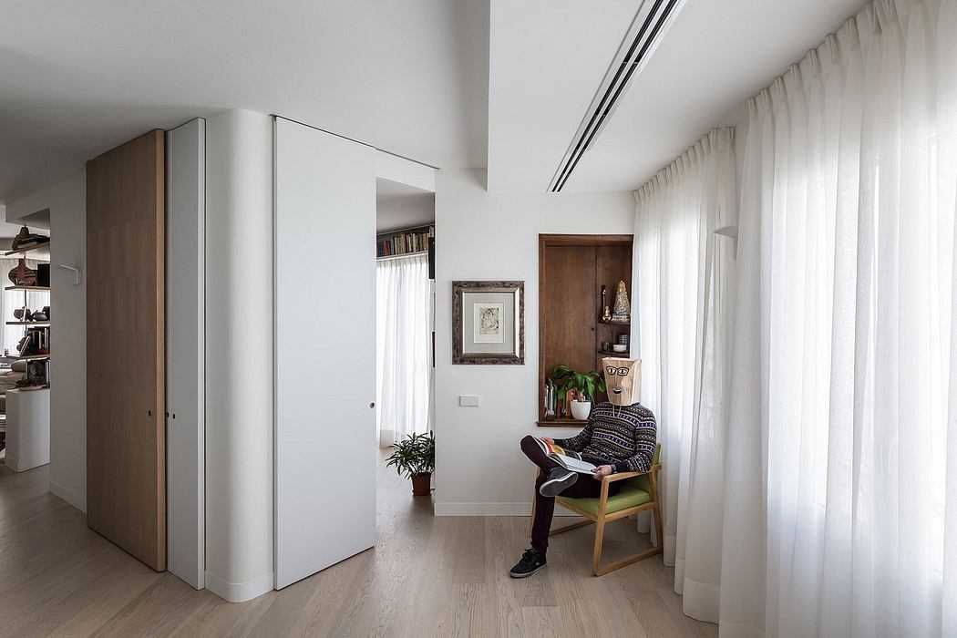 Minimalist interior design with neutral tones, wooden furniture, and suspended lighting.