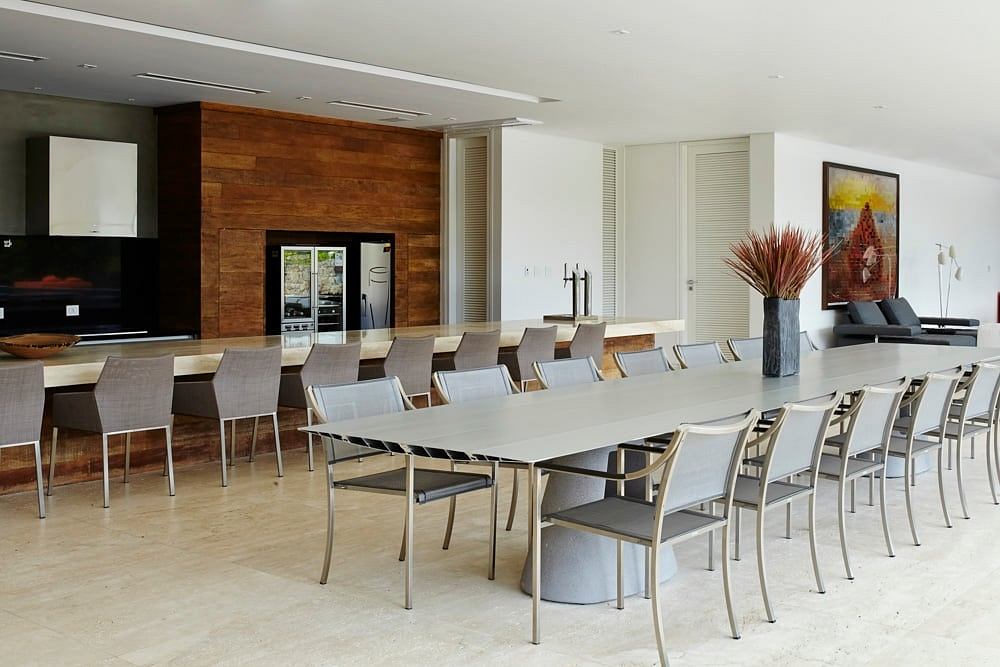 Spacious dining area with modern wooden wall panels, sleek gray furniture, and artwork.