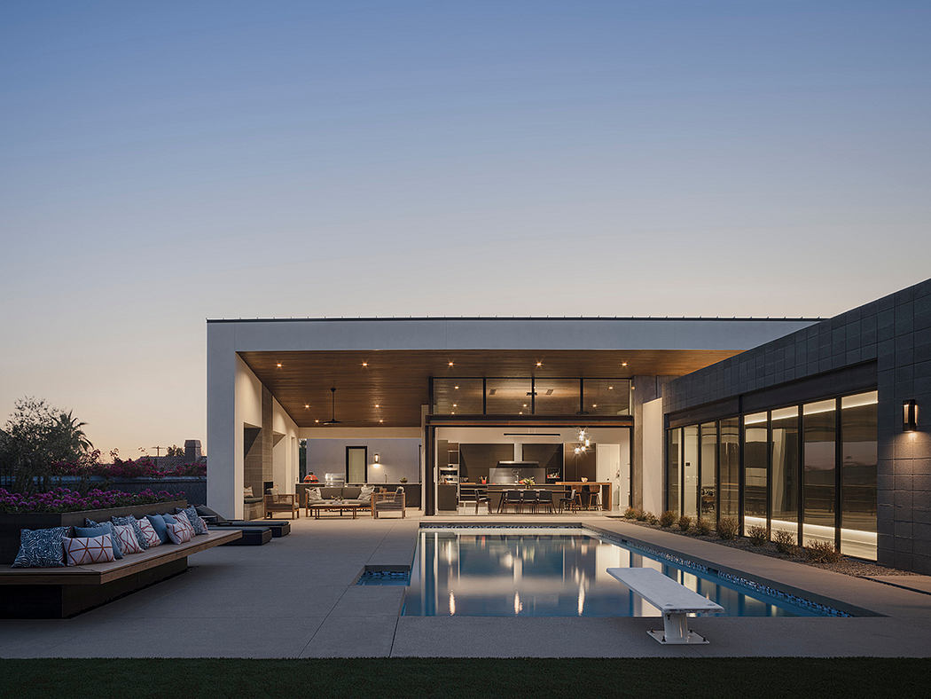 Sleek modern home with an outdoor pool, recessed lighting, and wood-paneled ceiling.