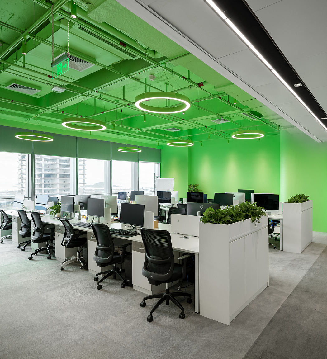 Modern, vibrant office space with green accents, suspended lighting, and natural elements.