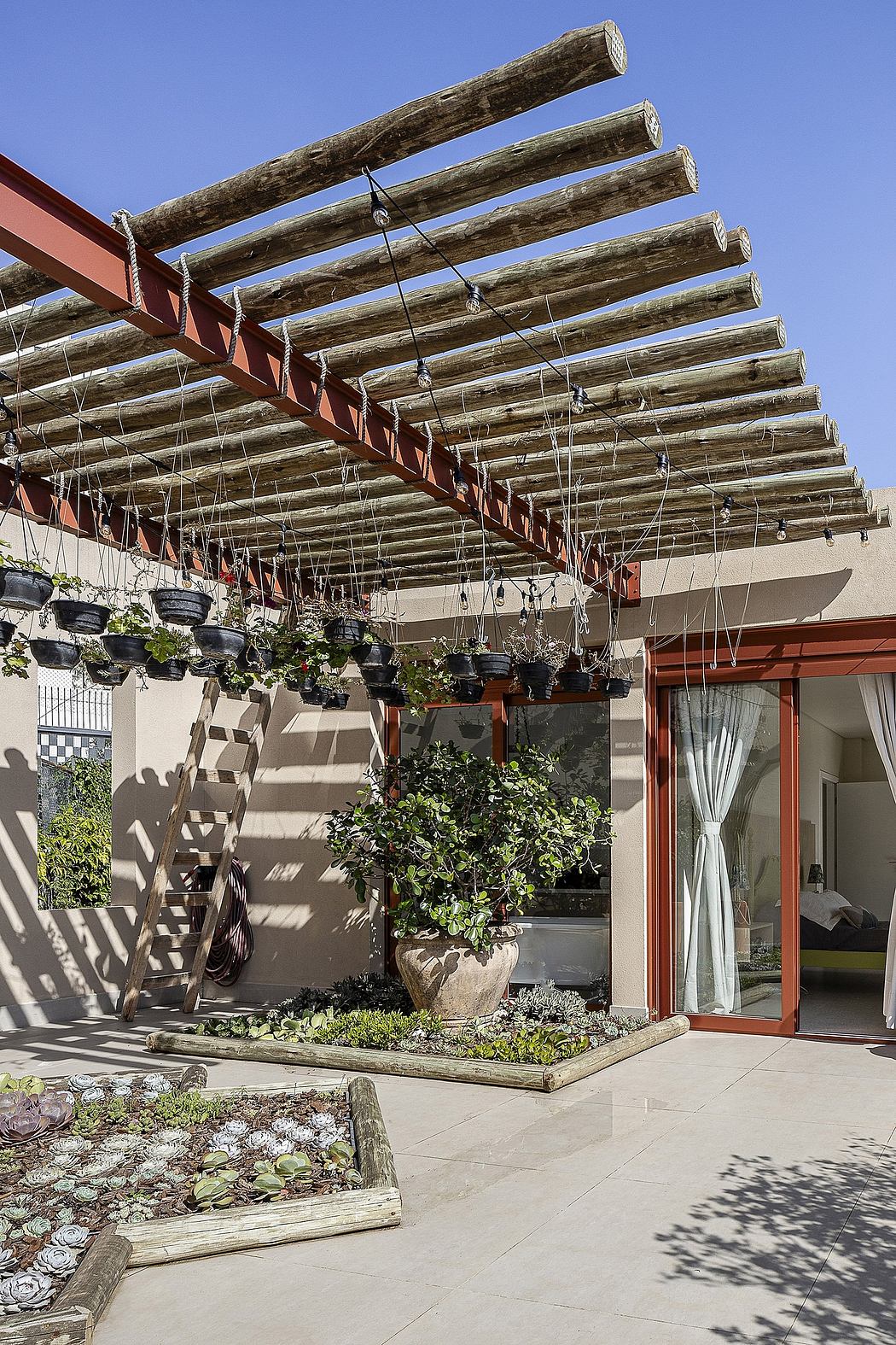 Wooden pergola structure with potted plants, stone walkway, and wooden accents.