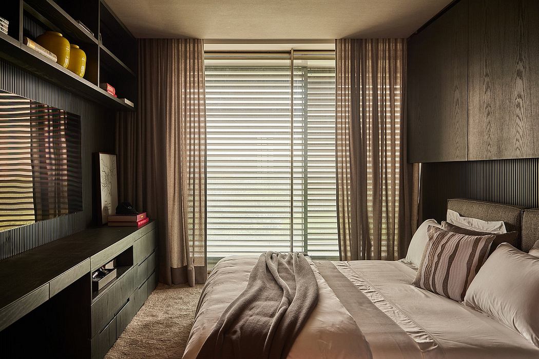 Warm tones, patterned curtains, and a modern entertainment unit create a cozy bedroom atmosphere.