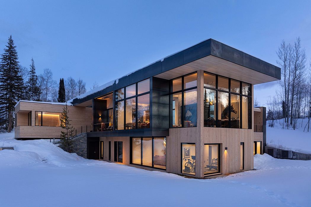 Sleek, modern alpine-inspired cabin with expansive glass walls and warm interior lighting.