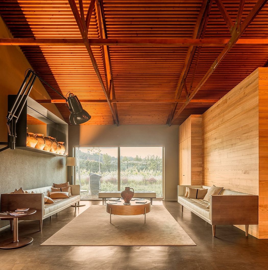 A warm, modern interior with wooden ceiling beams, large windows, and contemporary furnishings.