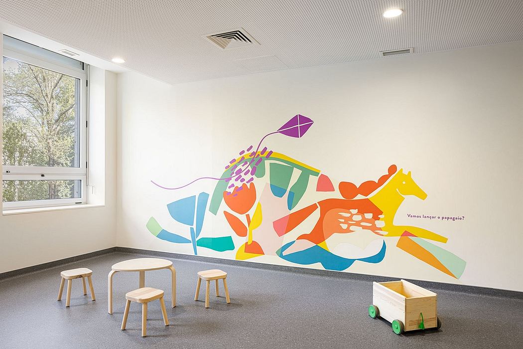 Bright, colorful wall mural featuring abstract shapes and a horse, with simple wooden furniture.