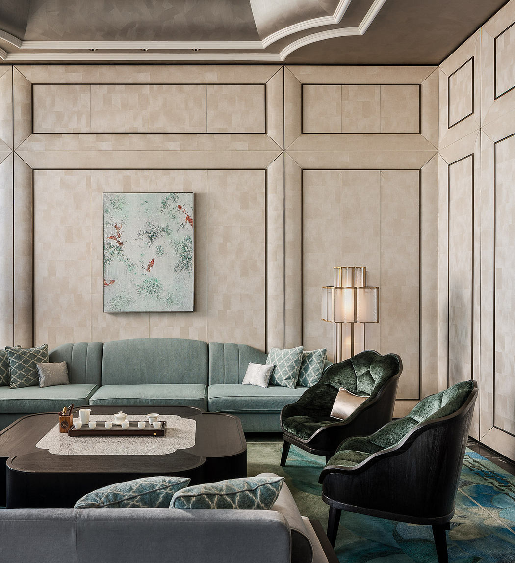 A luxurious living room with a plush gray sofa, abstract artwork, and a sleek lighting fixture.