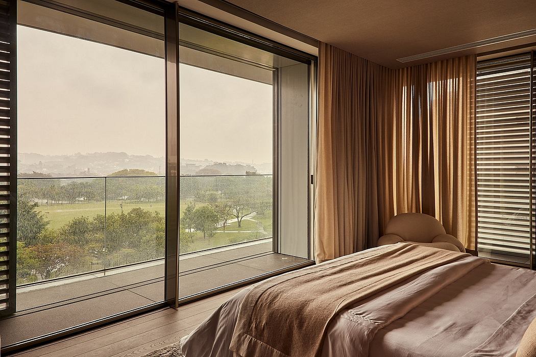 Luxurious bedroom with floor-to-ceiling glass windows overlooking a scenic landscape.