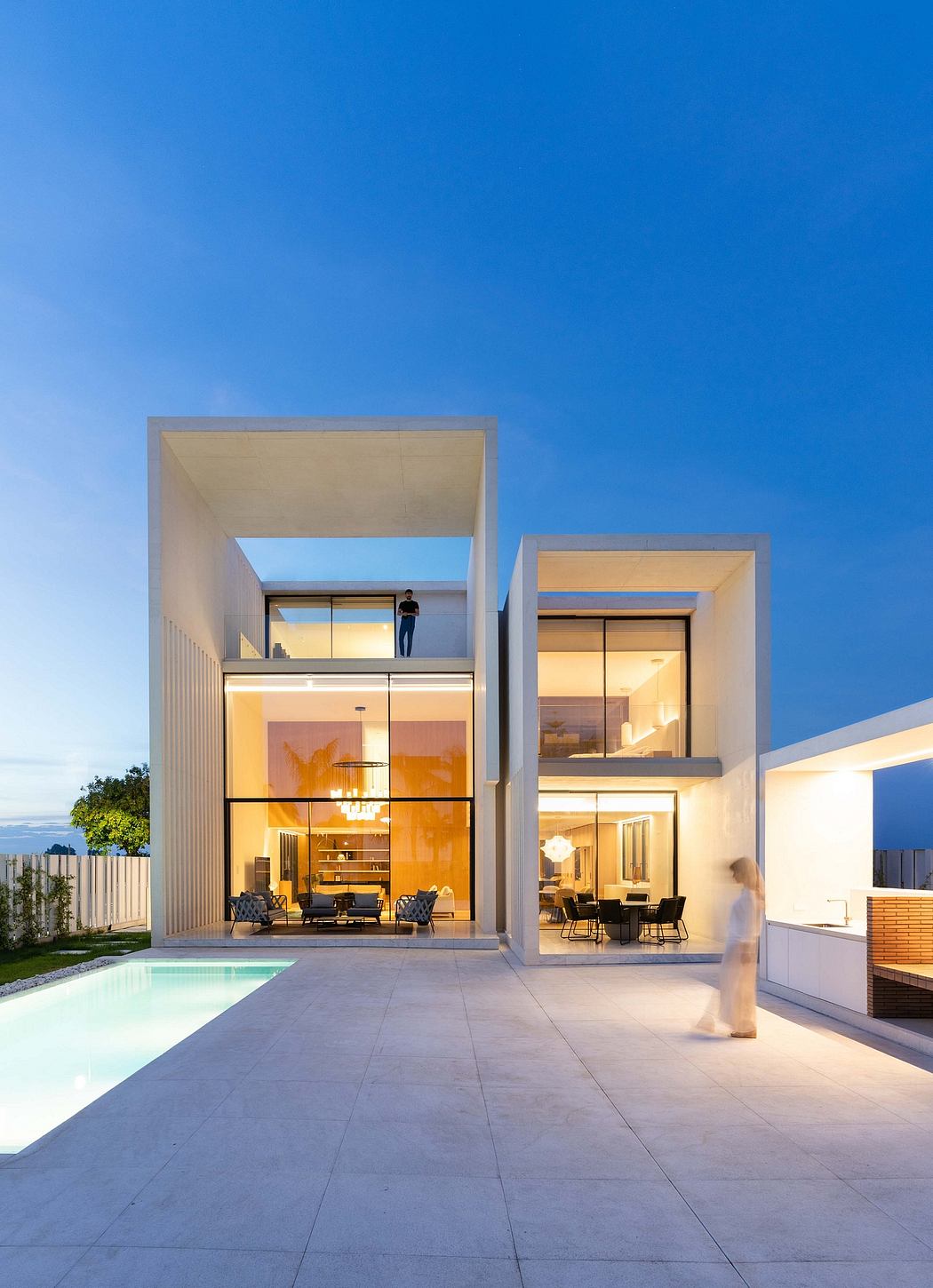 Sleek, modern architecture with floor-to-ceiling windows, outdoor pool, and lush greenery.